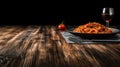 a black slate with hot italian spaghetti with pesto on the left side of a long Oak wood table Royalty Free Stock Photo