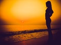 Black slhouette of slim girl on the sea beach. People meets the dawn. Summer vacation Royalty Free Stock Photo