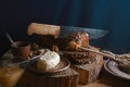 Black sliced bread on the board, vintage knife, butter, flax seed, than slicing bread on the table and a wooden background on a st Royalty Free Stock Photo