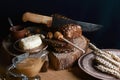 Black sliced bread on the board, vintage knife, butter and honey, flax seed, than slicing bread on the table and a wooden backgrou Royalty Free Stock Photo