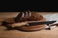 Black sliced bread on the board, vintage knife on the table and the old background, concept of healthy eating, place for text, set