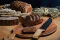 Black sliced bread on the board, vintage knife on the table and a wooden background on a stump, concept of healthy eating, place f Royalty Free Stock Photo