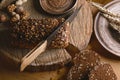 Black sliced bread on the board, vintage knife, wheat shoots, flax seed, than slicing bread on the table and a wooden background o Royalty Free Stock Photo