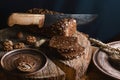 Black sliced bread on the board, vintage knife, wheat shoots, flax seed, than slicing bread on the table and a wooden background o Royalty Free Stock Photo