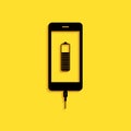 Black Smartphone battery charge icon isolated on yellow background. Phone with a low battery charge and with USB Royalty Free Stock Photo