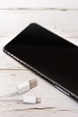 A black smartphone with a carbon fiber case on a white table a Royalty Free Stock Photo