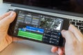 Black smartphone in hand. On-screen video editing program.