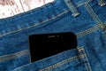 Black smartphone sticking out of his jeans pocket Royalty Free Stock Photo