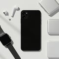 Black smartphone with triple camera setup, surrounded by wireless earbuds, portable Royalty Free Stock Photo
