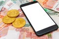 A black smartphone with a white screen lies on rubles and bitcoin. Russian money Royalty Free Stock Photo