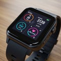 A black smartwatch featuring a square touch screen display. The interface shows