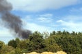 black smoke from burning forest trees and buildings Royalty Free Stock Photo