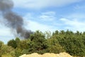 black smoke from burning forest trees and buildings Royalty Free Stock Photo