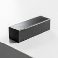 A black smooth rectangular block with sharp edges rests on a white surface Royalty Free Stock Photo