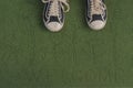 Black sneakers on a green welcome mat Royalty Free Stock Photo