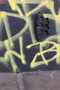 Black socket on the black wall painted with yellow graffiti. Street style. Urban. Royalty Free Stock Photo