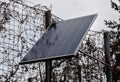 Black solar panel frozen by hoarfrost on the street. used to charge the device parking meter, information interactive screen, traf