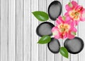 Black spa stones and pink orchid on white wooden Royalty Free Stock Photo