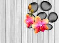 Black spa stones and pink orchid on white wooden Royalty Free Stock Photo