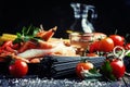 Black spaghetti, cherry tomatoes, white wine, shrimp, squid, still life in low key, selective focus Royalty Free Stock Photo