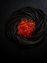 Black spaghetti with red caviar, pasta, on a black background, top view, no people, Royalty Free Stock Photo