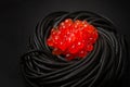 Black spaghetti with red caviar, pasta, on a black background, top view, no people, Royalty Free Stock Photo