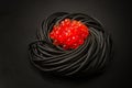 Black spaghetti with red caviar, pasta, on a black background, top view, no people, Royalty Free Stock Photo