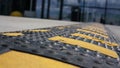 Black speed bump with yellow stripes on grey asphalt road