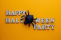 Black spider instead of the letter O on a stylish inscription HAPPY HALLOWEEN PARTY. Words from wooden letters on a bright orange Royalty Free Stock Photo