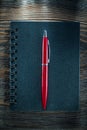 Black spiral notebook pen on vintage wooden board Royalty Free Stock Photo