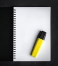 Black spiral notebook with yellow marker