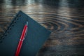 Black spiral notepad pen on vintage wooden board Royalty Free Stock Photo
