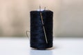 Black spool of sewing threads isolated on blurred background Royalty Free Stock Photo