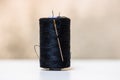 Black spool of sewing threads isolated on blurred background Royalty Free Stock Photo