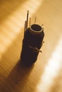 Black spool of thread with many different needles on the brown sunny table Royalty Free Stock Photo