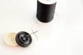Black spool of thread, needle, and black and white buttons Royalty Free Stock Photo