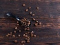 Black spoon with roasted cofee beans on wooden background Royalty Free Stock Photo