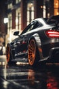 a black sport car on a city street at night, street lights reflected in wet asphalt after rain Royalty Free Stock Photo