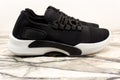 Black sport unisex sneakers with white sole and white laces on white background