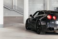 Black sports car on a gray background. View from behind. Royalty Free Stock Photo