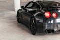 Black sports car on a gray background. View from behind. Royalty Free Stock Photo