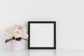 Black square frame mockup with pink roses in a pot on a white table Royalty Free Stock Photo