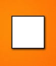 Black square picture frame hanging on an orange wall