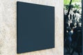 Black square signboard on the marble wall of a modern business center, mock up