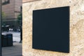 Black square signboard on the marble wall of a modern shopping center, mockup