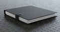 A black squared binder with paper sheets resting on a textured metal table Royalty Free Stock Photo