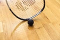 Black squash ball and tennis racket in tennis club