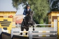 Black stallion horse and handsome man rider jumping obstacle Royalty Free Stock Photo