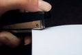 Black stapler and a sheet of paper in hand Royalty Free Stock Photo