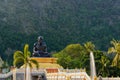 Black statue of Buddhist Monk Sitting. Elephant mountain on background Royalty Free Stock Photo